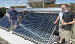 Des hommes devant une installation solaire thermique