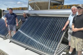 Des hommes devant une installation solaire thermique