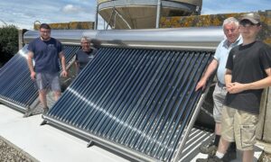 Des hommes devant une installation solaire thermique