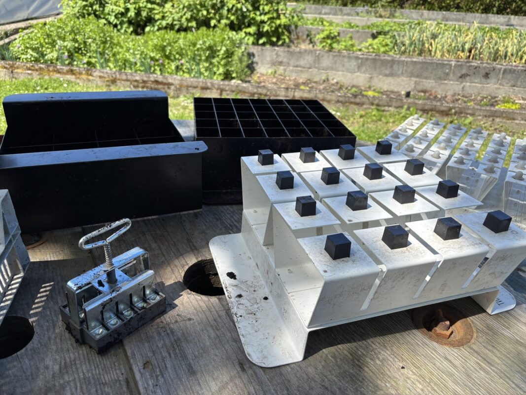 Des outils de fabrication de mottes horticoles posés sur une table