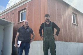 Deux hommes devant une porcherie