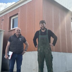 Deux hommes devant une porcherie