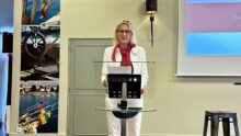 Une femme debout derrière un pupitre de conférence