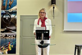 Une femme debout derrière un pupitre de conférence