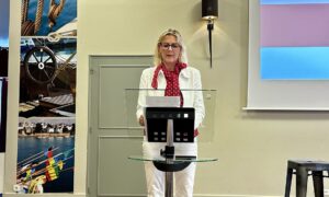 Une femme debout derrière un pupitre de conférence