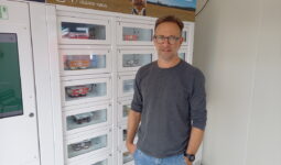 Un homme devant un distributeur automatique de produits laitiers