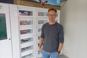 Un homme devant un distributeur automatique de produits laitiers