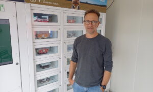 Un homme devant un distributeur automatique de produits laitiers