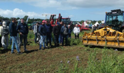 Des personnes assistent à une démonstration de matériel agricole en plein champ