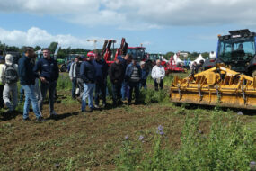 Des personnes assistent à une démonstration de matériel agricole en plein champ