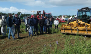 Des personnes assistent à une démonstration de matériel agricole en plein champ