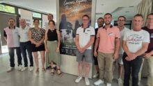 Des hommes et femmes devant une affiche