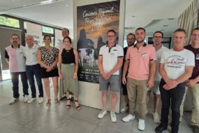 Des hommes et femmes devant une affiche