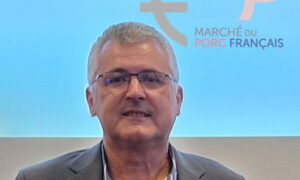 Un homme devant un écran avec le logo du Marché du Porc Français