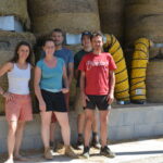 Un groupe de personnes devant des rounds de foin