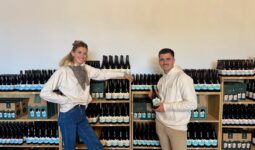 Un jeune couple devant un rayonnage de bouteilles de bières
