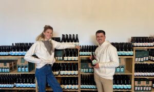Un jeune couple devant un rayonnage de bouteilles de bières