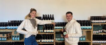 Un jeune couple devant un rayonnage de bouteilles de bières