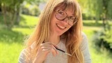 Une jeune femme souriant dans un paysage de campagne