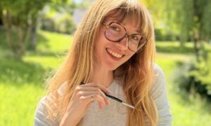Une jeune femme souriant dans un paysage de campagne