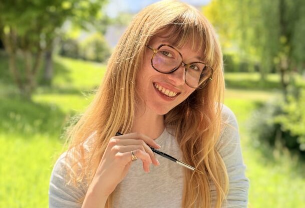 Une jeune femme souriant dans un paysage de campagne