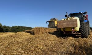 Un tracteur et une moissonneuse au travail dans un champ