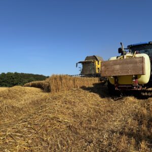 Un tracteur et une moissonneuse au travail dans un champ