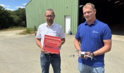 Deux homme devant un bâtiment agricole