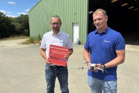 Deux homme devant un bâtiment agricole