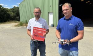 Deux homme devant un bâtiment agricole