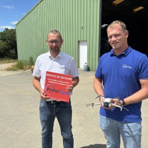Deux homme devant un bâtiment agricole