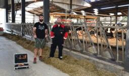 Deux hommes devant des cornadis avec des robots dans le fond
