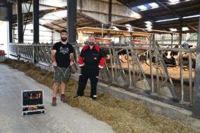 Deux hommes devant des cornadis avec des robots dans le fond