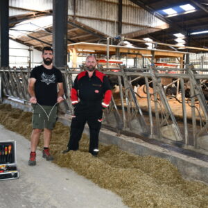 Deux hommes devant des cornadis avec des robots dans le fond