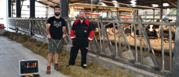 Deux hommes devant des cornadis avec des robots dans le fond