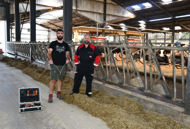 Deux hommes devant des cornadis avec des robots dans le fond