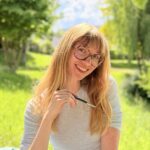 une jeune femme souriant dans un paysage de campagne