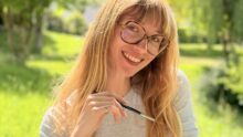 une jeune femme souriant dans un paysage de campagne