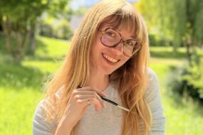 une jeune femme souriant dans un paysage de campagne