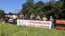 Des personnes dans un champ avec une banderole et du matériel argicole