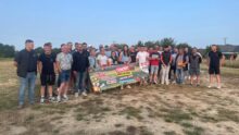 Un groupe de personnes pose pour une photo dans un champ