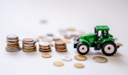 Un tracteur miniature avec des piles de pièces de monnaie