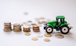 Un tracteur miniature avec des piles de pièces de monnaie