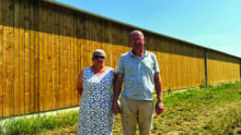 couple d'éleveurs devant un bâtiment agricole
