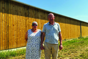 couple d'éleveurs devant un bâtiment agricole