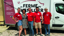 Des femmes et des hommes posent devant un camion de vente directe