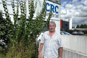 Un homme devant un bâtiment d'entreprise