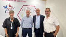 quatre personnes posent devant une affiche "Le porc français"