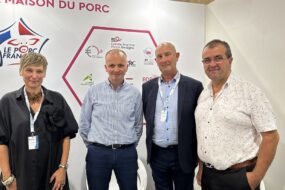 quatre personnes posent devant une affiche "Le porc français"