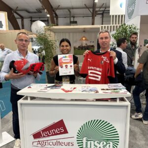 Des personnes présentent des objets publicitaires sur un stand lors d'un salon